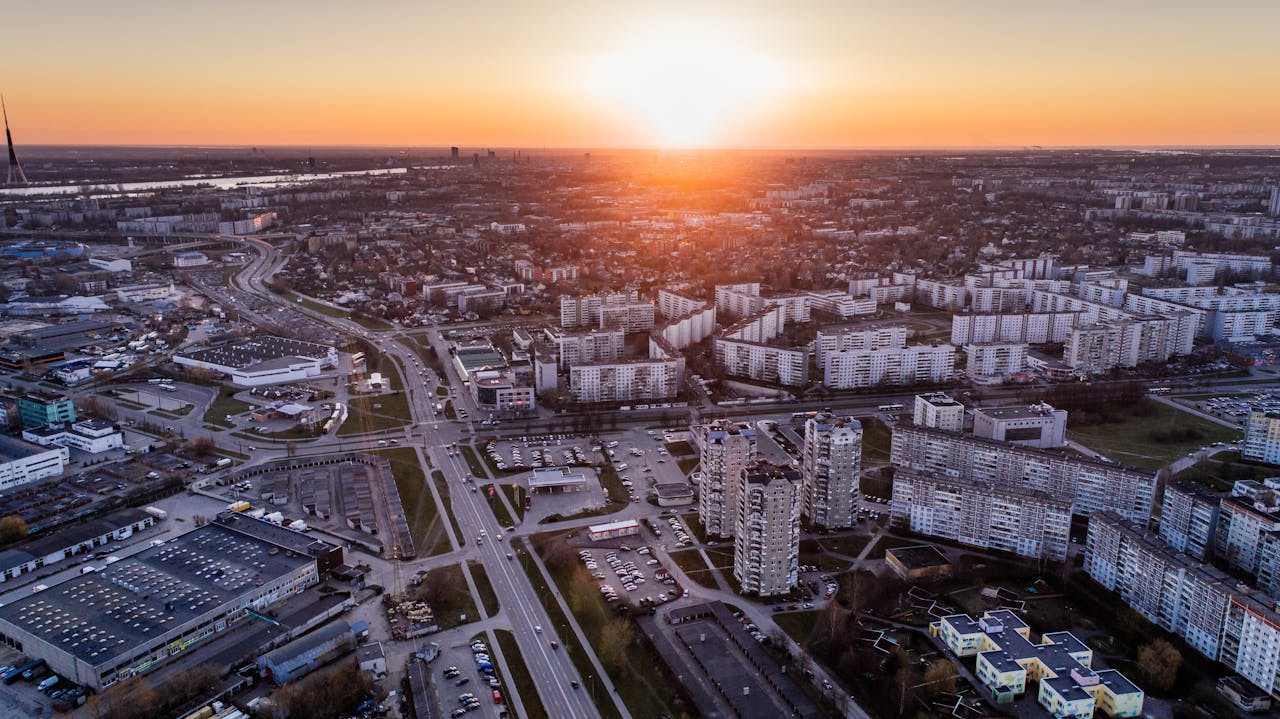 Breathtaking aerial view of a city's urban landscape at sunrise, showcasing modern architecture and vibrant streets.